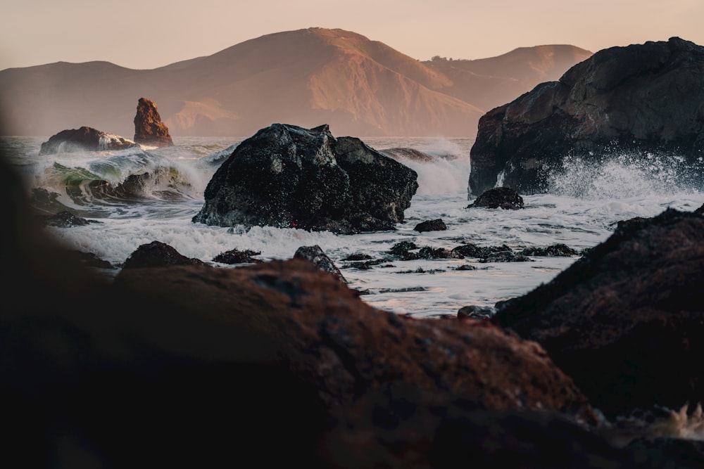 a rocky beach with waves crashing against it