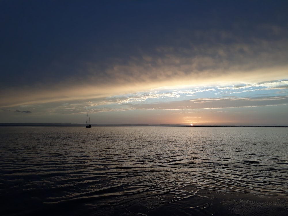 a body of water with a boat in it and a blue sky above