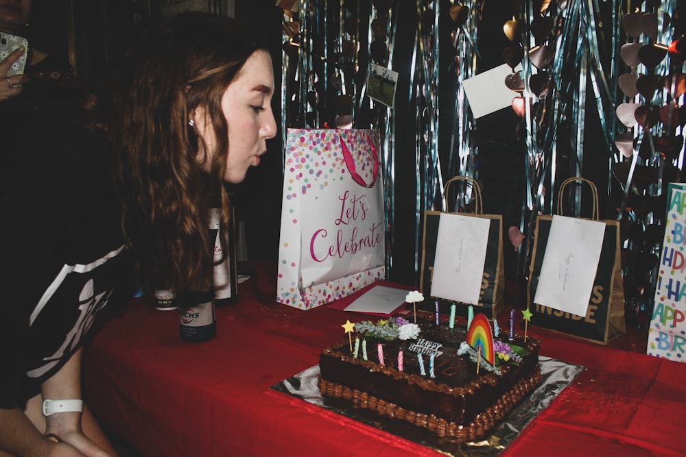 a person blowing out candles on a cake