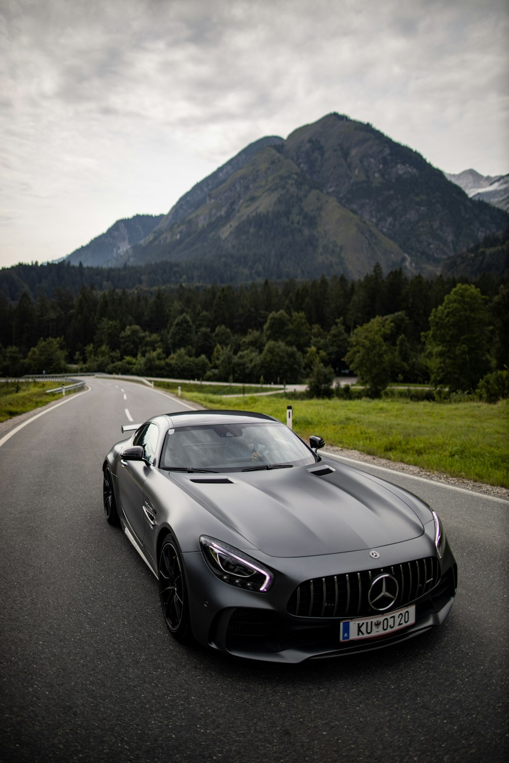 a car on a road with a mountain in the background