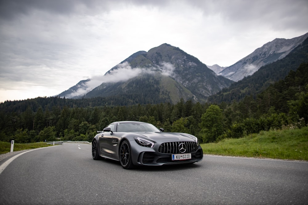 a car driving on a road with mountains in the background