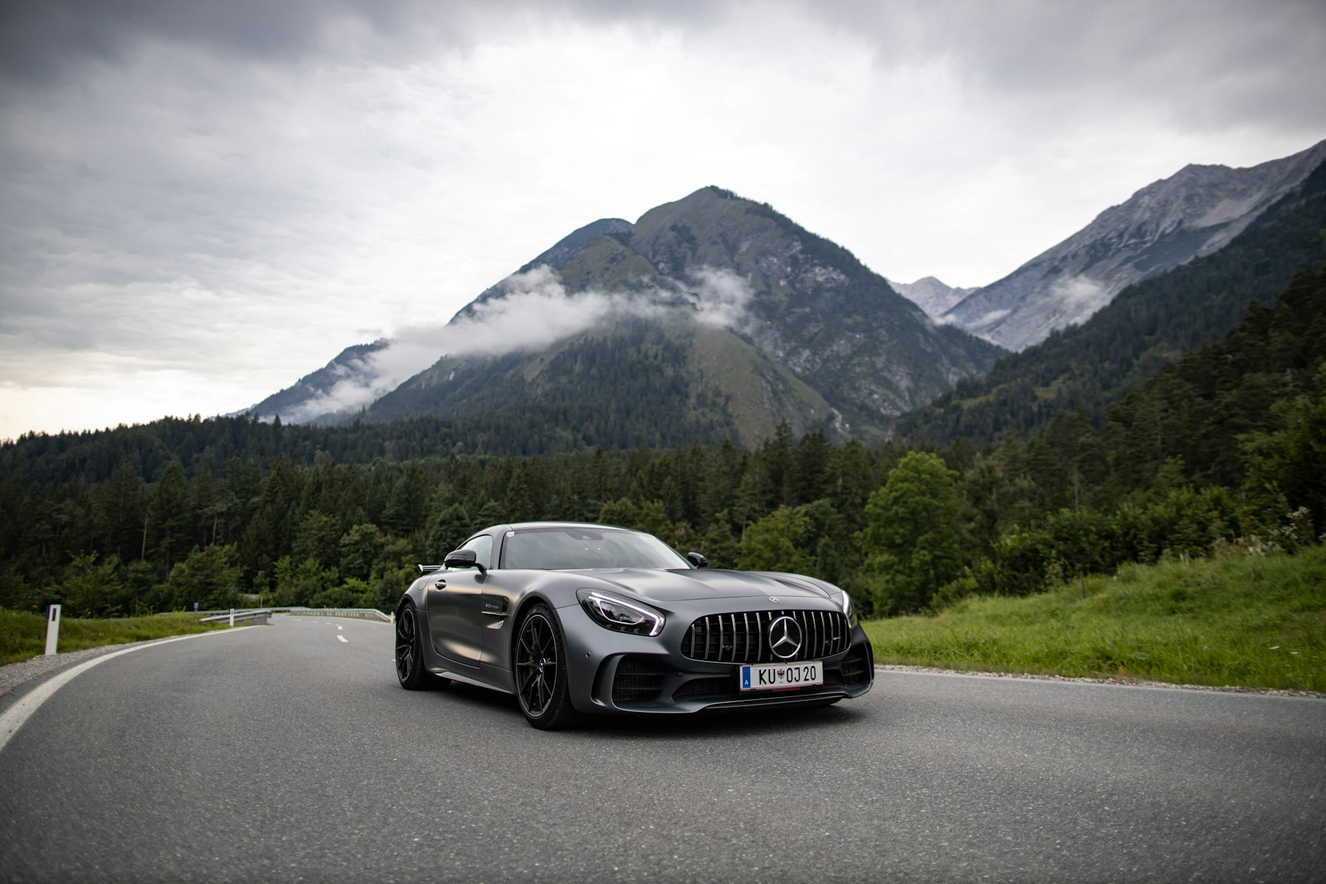 a car driving on a road with mountains in the background