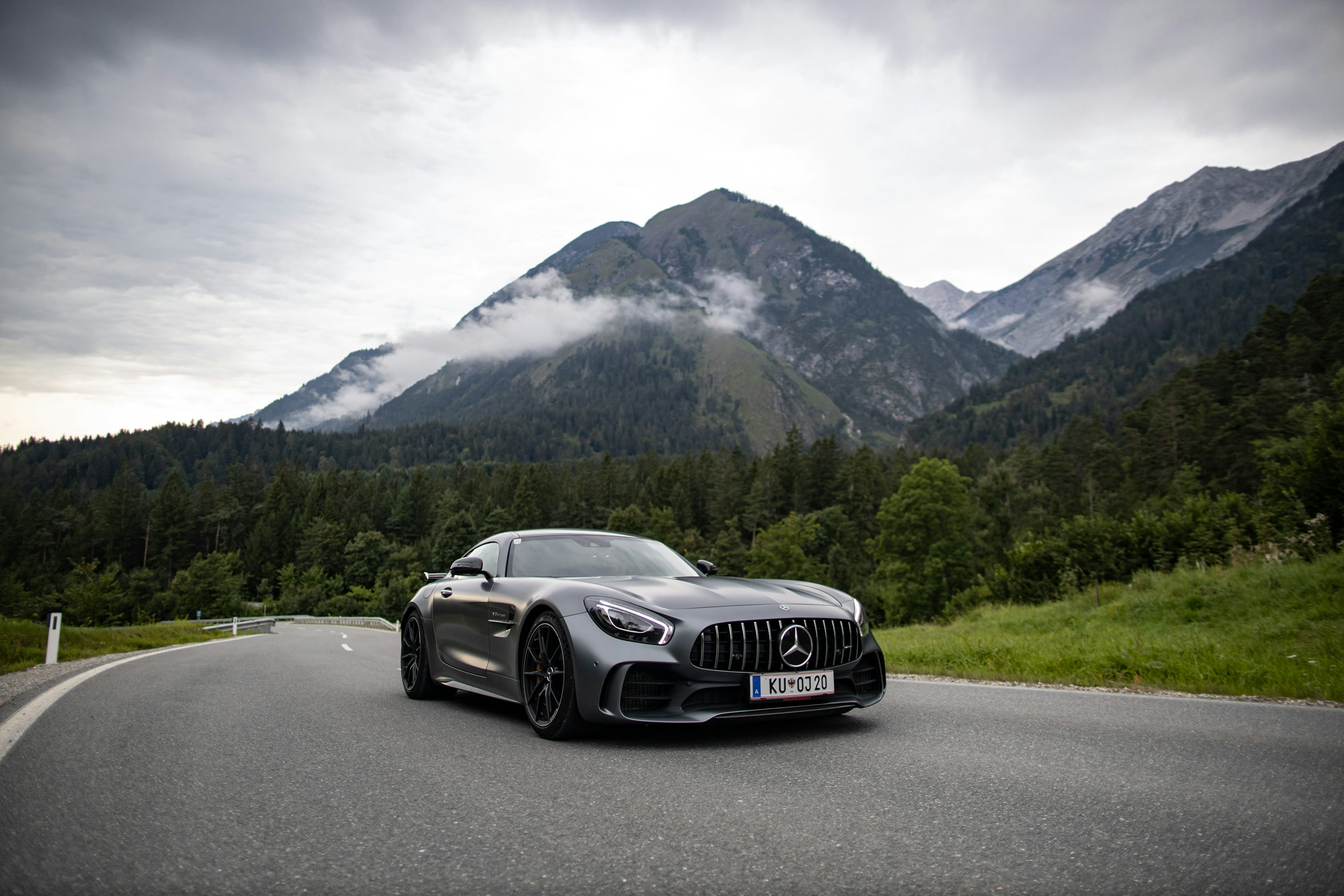 a car driving on a road with mountains in the background