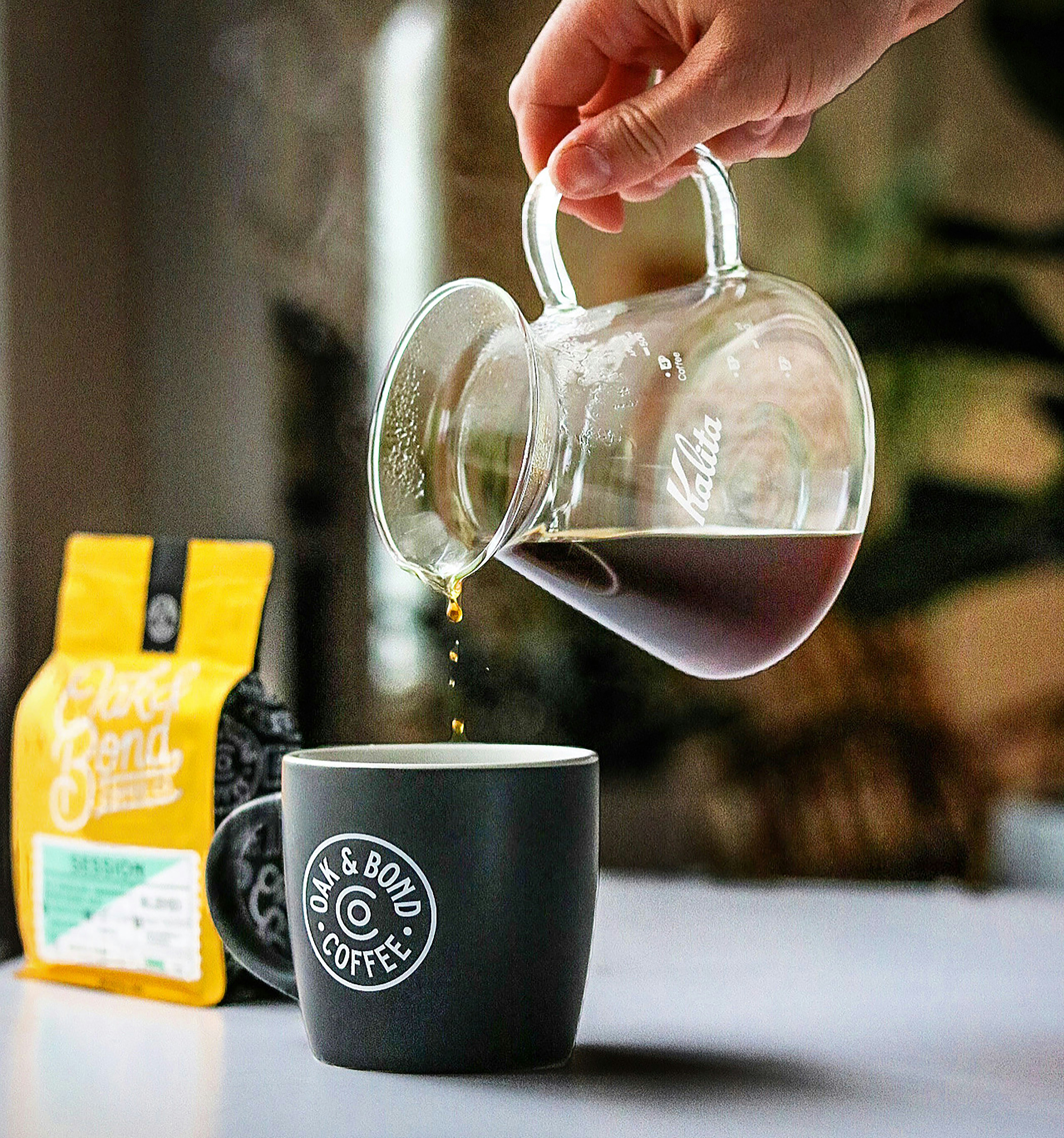 a hand pouring a glass of red wine into a glass
