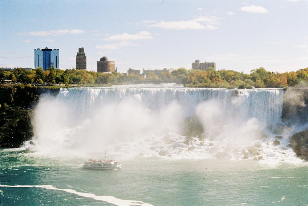 a large waterfall with a boat in the water