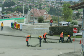 a group of people in orange vests working on a road