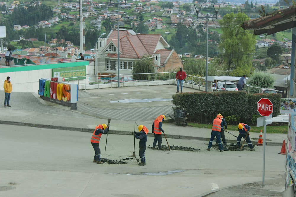 a group of people in orange vests working on a road