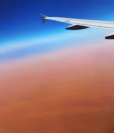 Scenic view of an airplane taking off over Egyptian desert landscape during sunset.