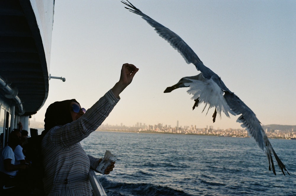 a person holding a bird on a boat