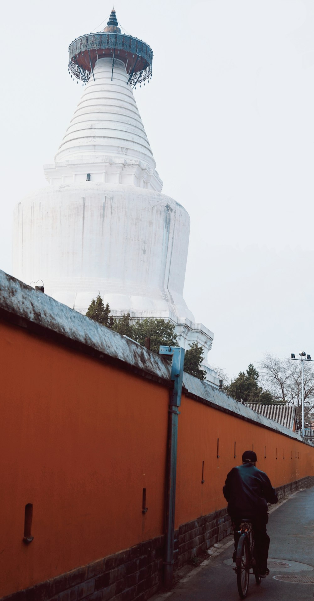 a person riding a bicycle next to a large building