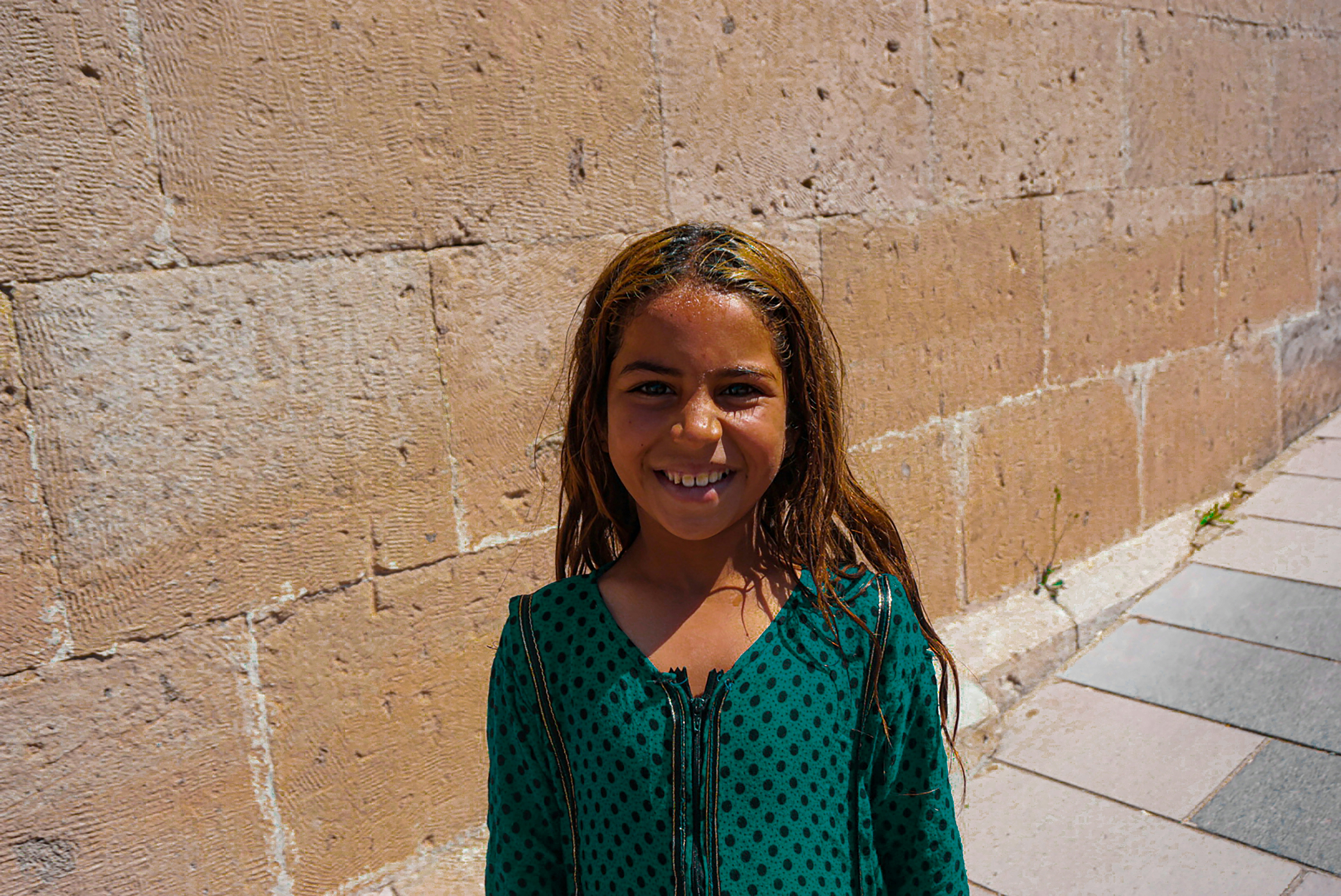 A woman smiling in front of a brick wall photo – Free Smiley face Image ...