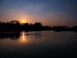 A sunset view over a calm lake, reflecting warm colors.