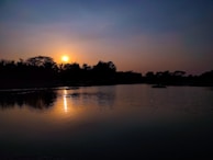 Sunset over a calm lake, reflecting warm colors and inviting stillness.