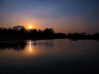 A serene sunset flight with a hot air balloon casting a warm glow over a calm lake