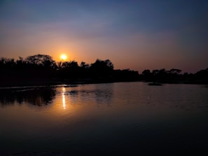 A scenic sunset over a calm lake with soft reflections and warm colors.