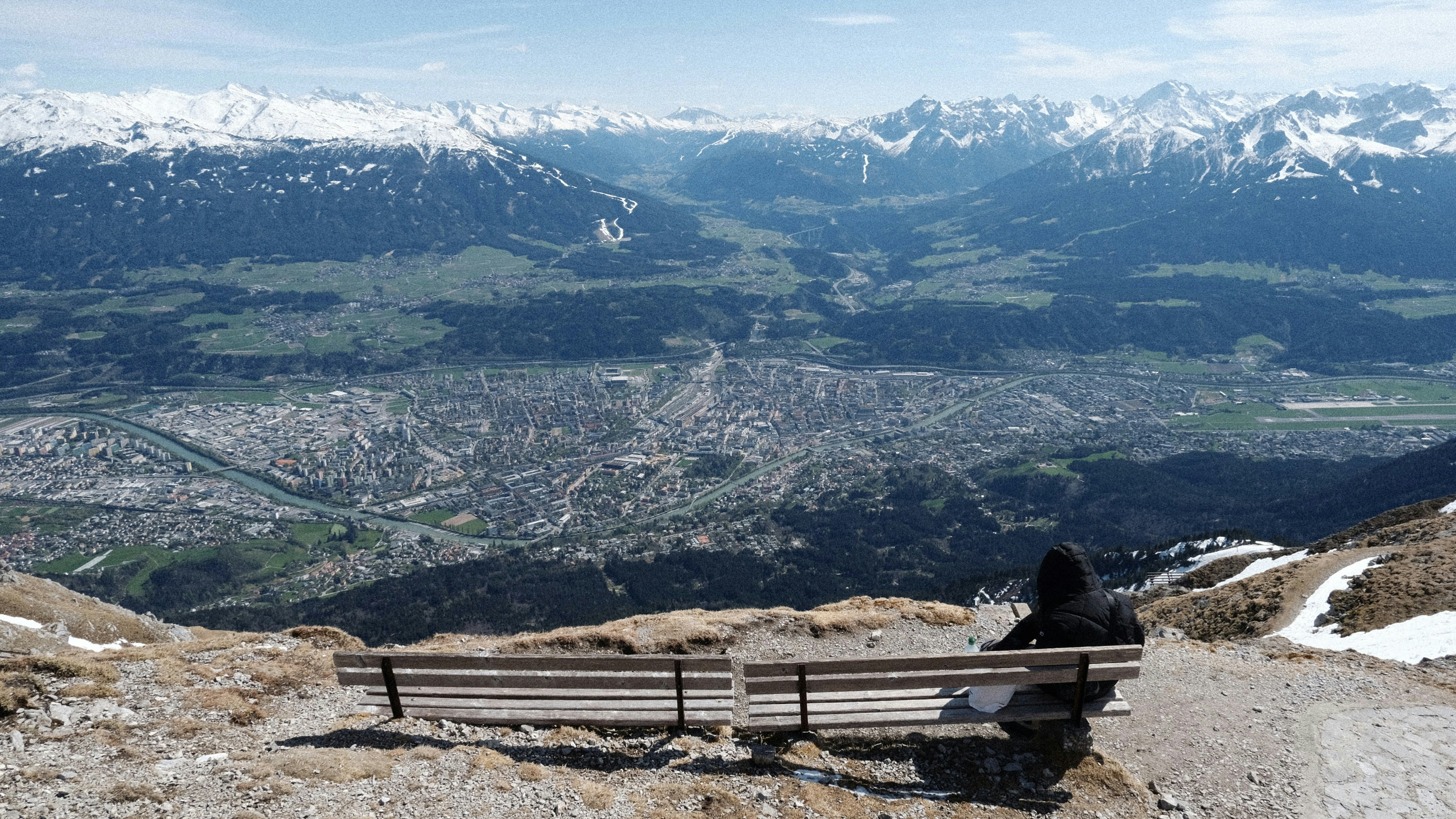 a person sitting on a bench overlooking a mountain range
