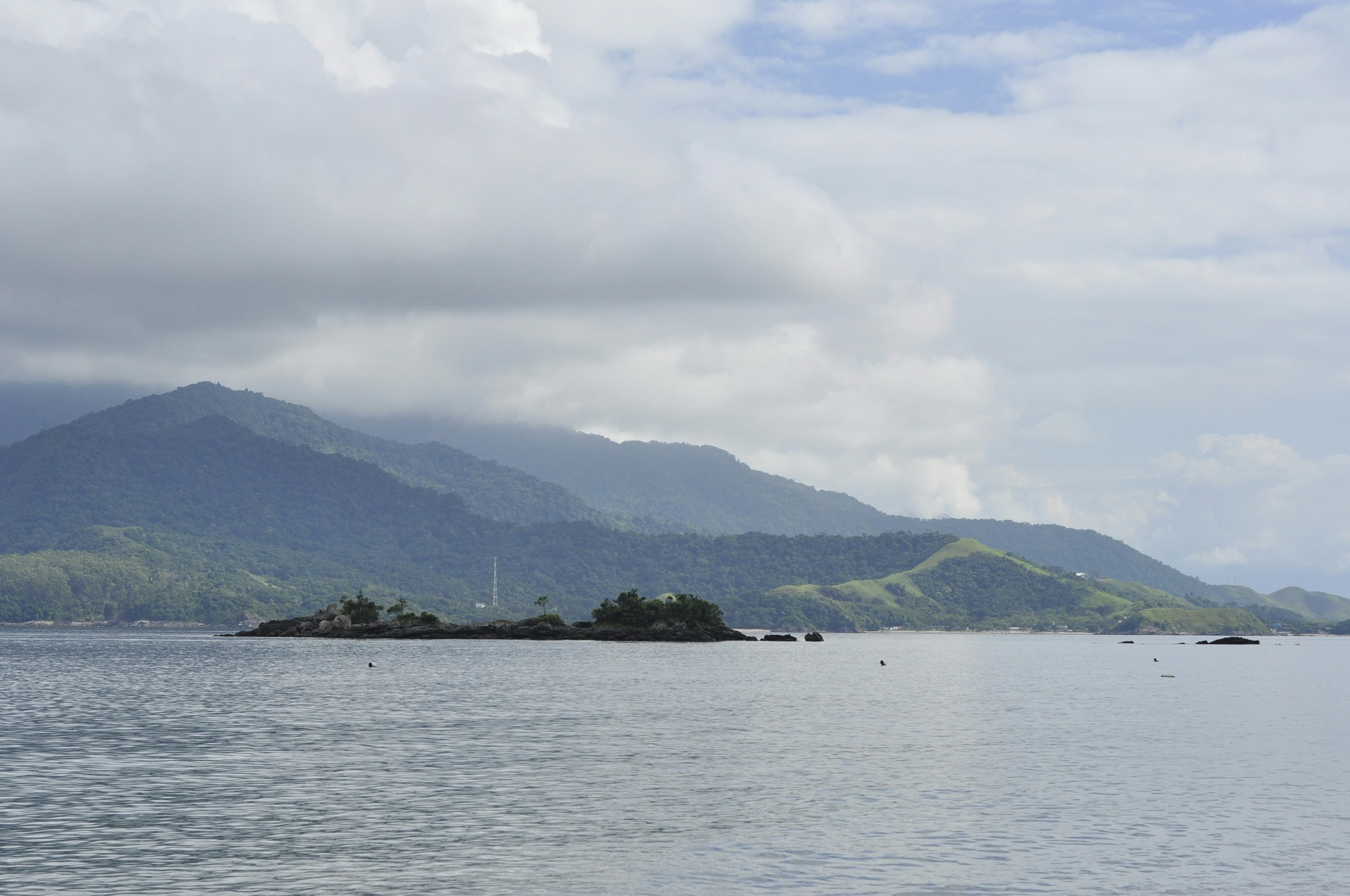 a body of water with islands in it and mountains in the background