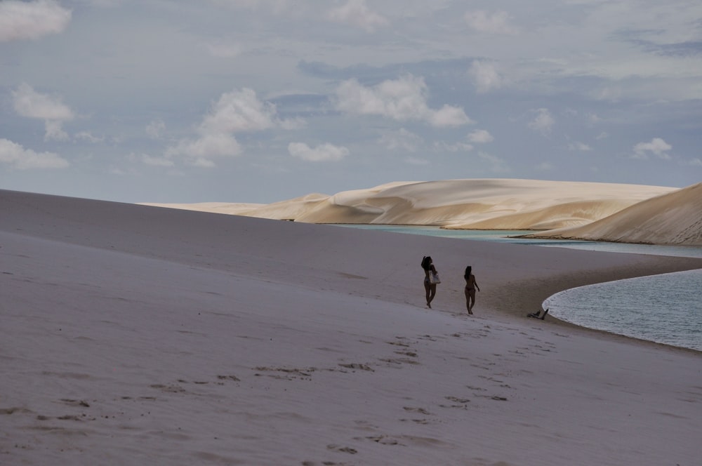 people walking on a sandy beach