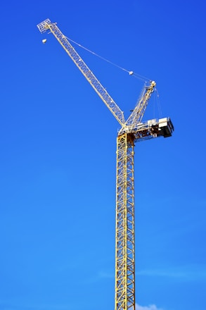 A sturdy JLG 800 boom lift positioned on a construction site under a clear blue sky.