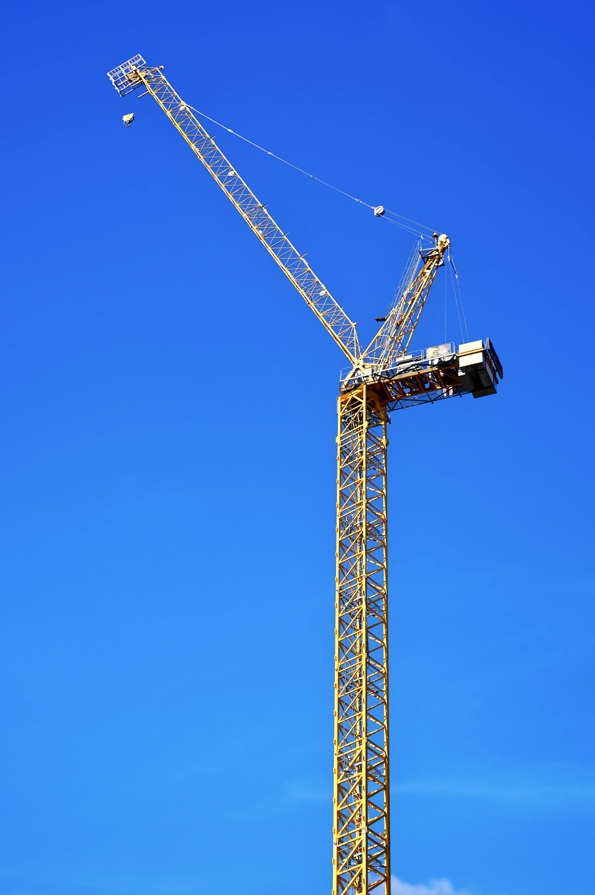 A sleek yellow articulating boom lift from Youxi operating smoothly against a clear blue sky.