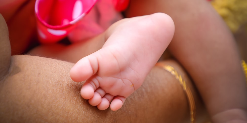 a close-up of a hand holding a baby's hand