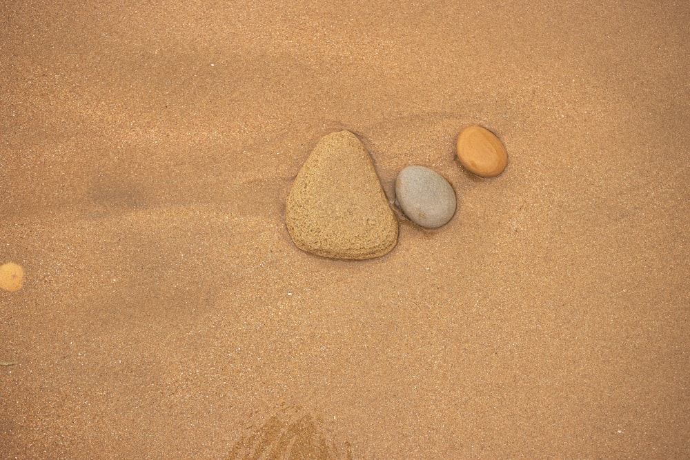 a group of rocks on a sandy surface