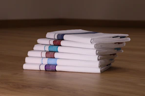 A collection of colorful pocket squares neatly arranged on a rustic table, highlighting their intricate designs.