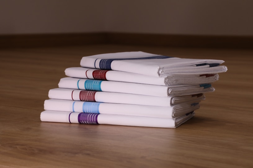 A stack of soft, white facial tissues on a wooden table.