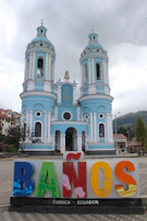 a blue and white building with a tower and a sign in front