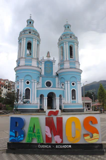 a blue and white building with a tower and a sign in front