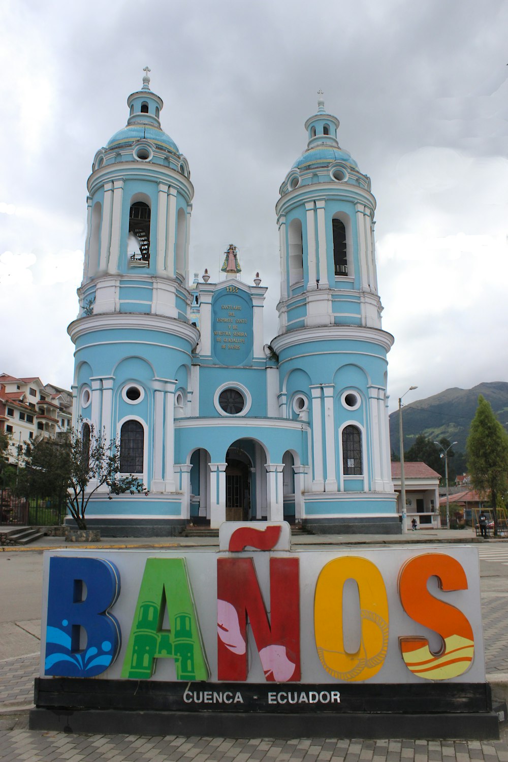 a blue and white building with a tower and a sign in front