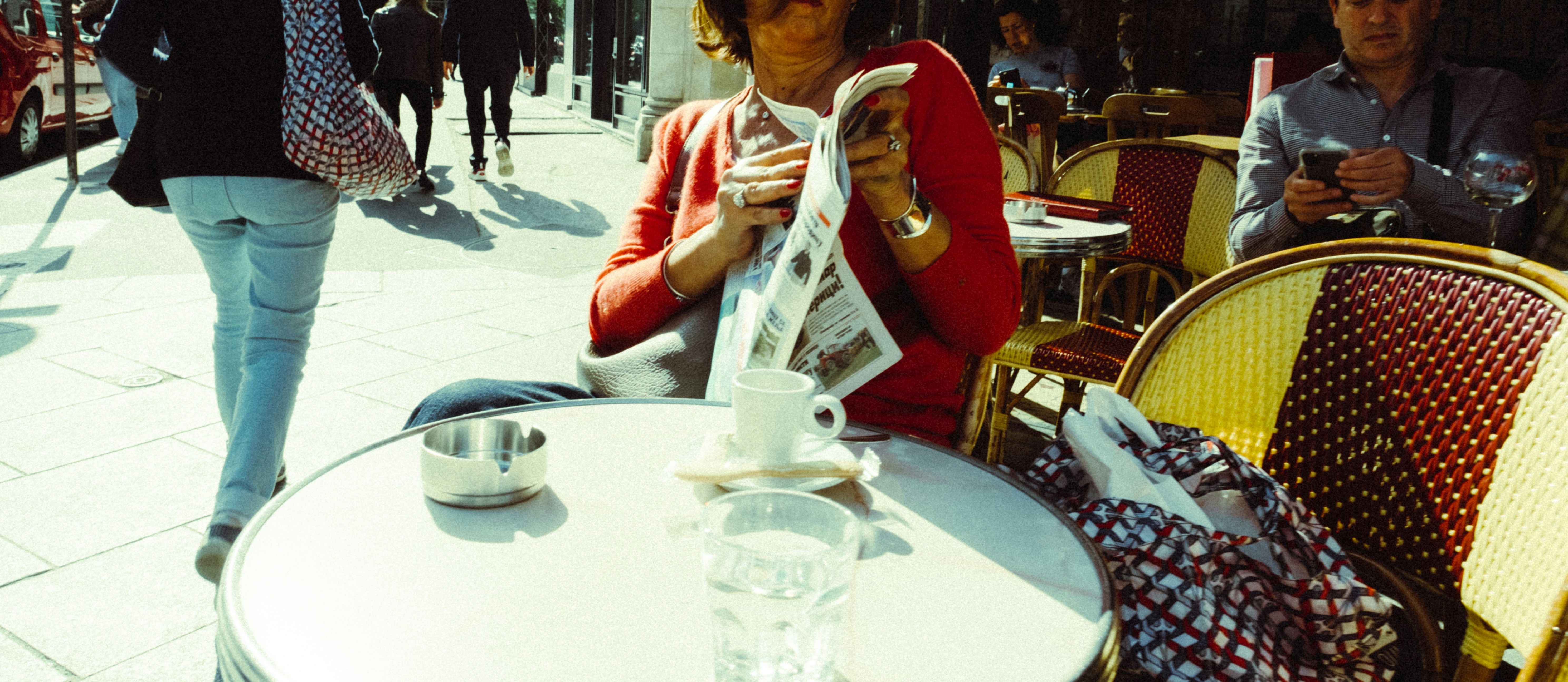 a person sitting at a table reading a newspaper