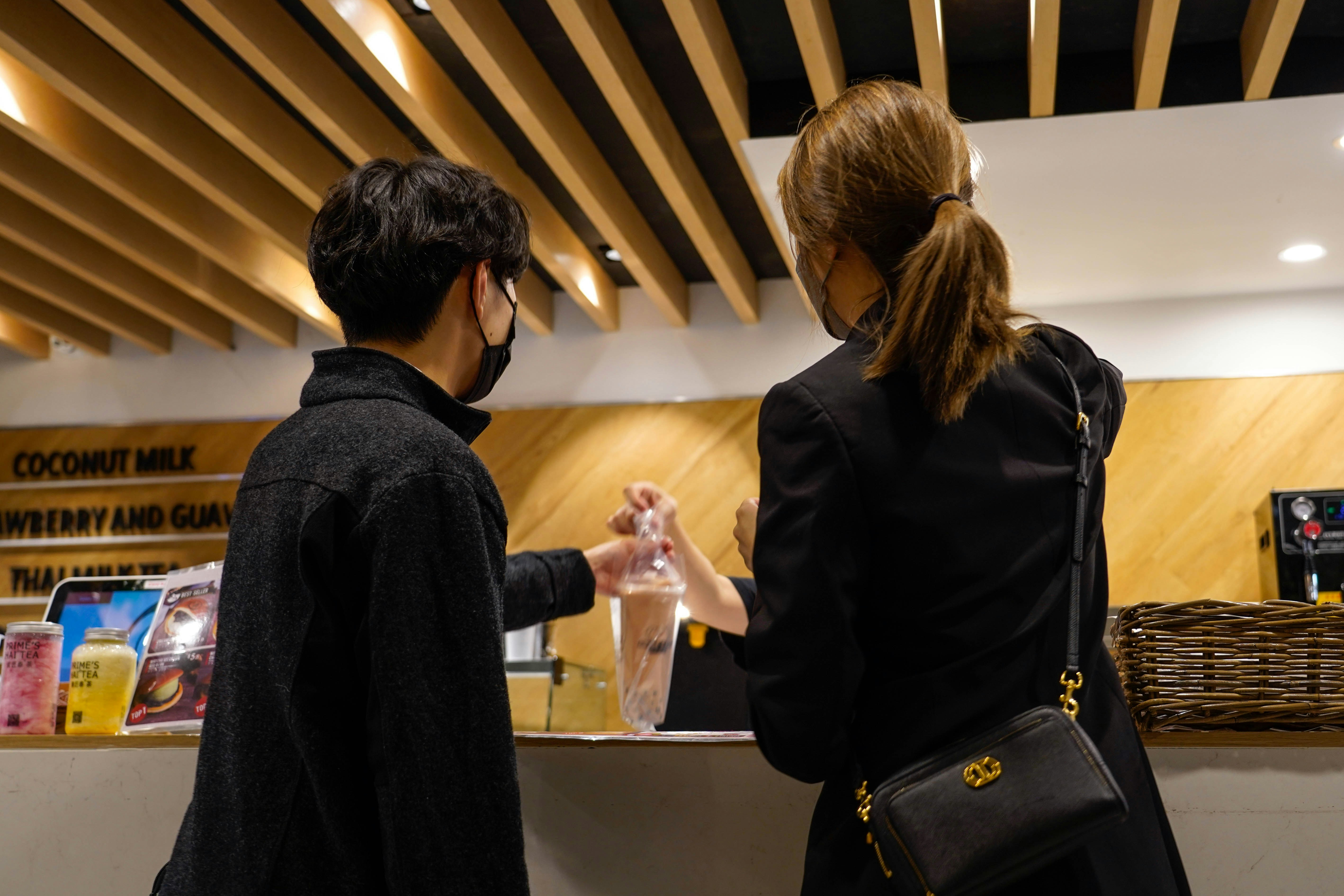 A man and woman in business attire shake hands over a sleek, modern desk in a bright office, symbolizing a successful real estate negotiation and closing.