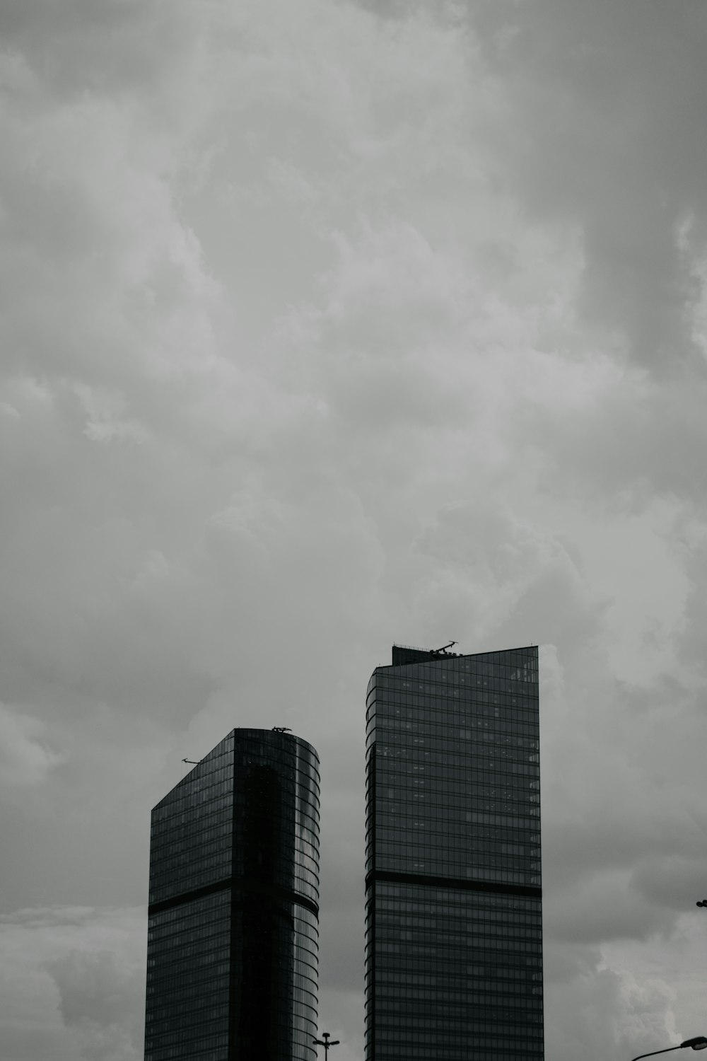 two tall buildings under a cloudy sky