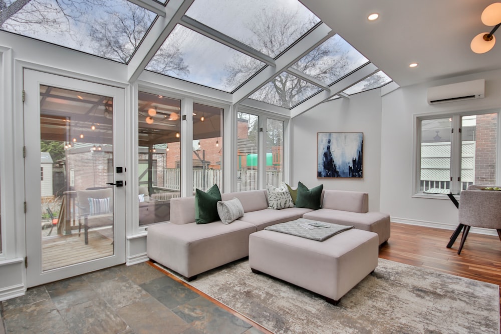 a living room with a large glass wall and a white couch