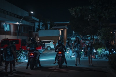 An urban anime-inspired scene of a group of riders gathered around a glowing mystical symbol painted on the street.