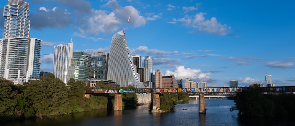 a bridge over a river with a city in the background