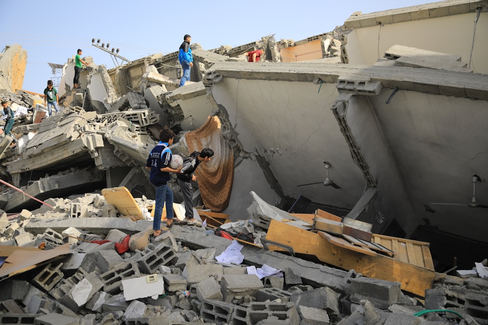 Un gruppo di persone in piedi accanto a un edificio crollato