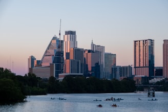 a group of boats in a body of water with a city in the background
