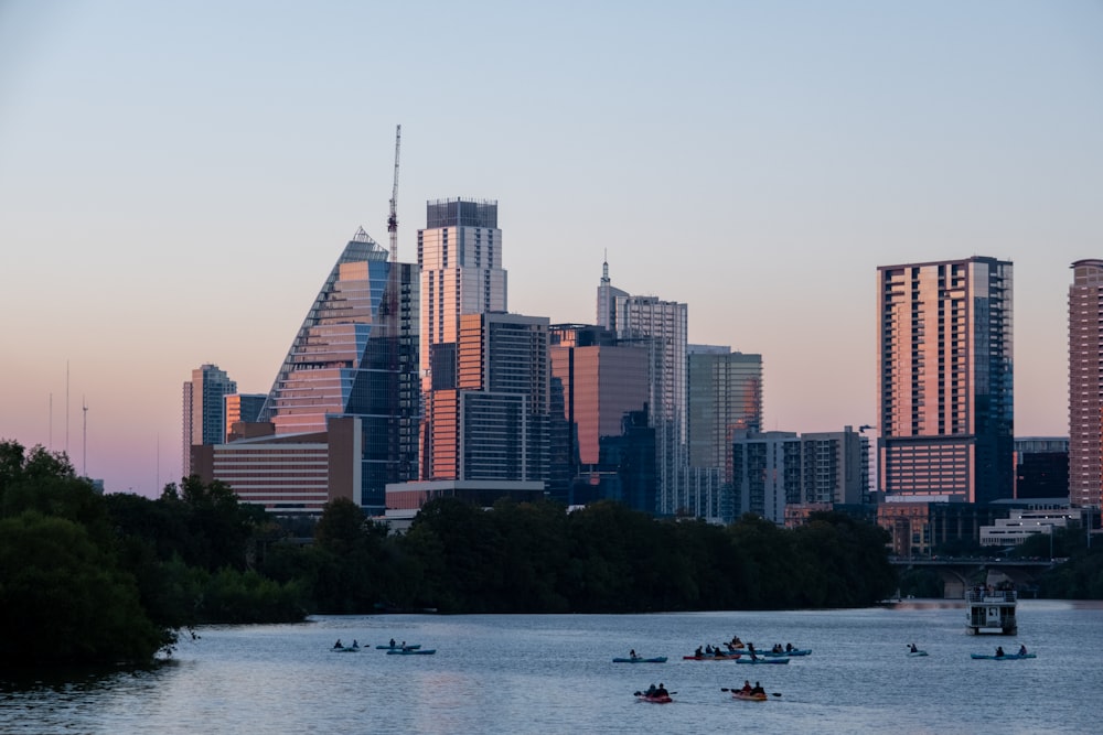 a group of boats in a body of water with a city in the background