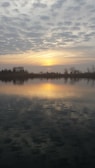 A tranquil scene of a sunset over a calm lake.
