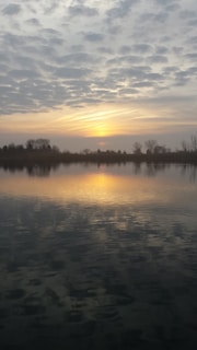 A peaceful scene of a sunset over a calm lake.