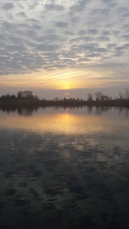 A peaceful scene of a sunset over a calm lake.