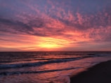 A vibrant sunset over a tranquil beach setting.