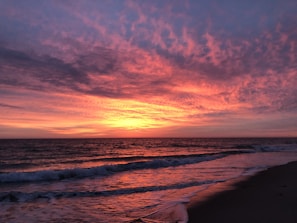 A vibrant sunset over a calm beach.