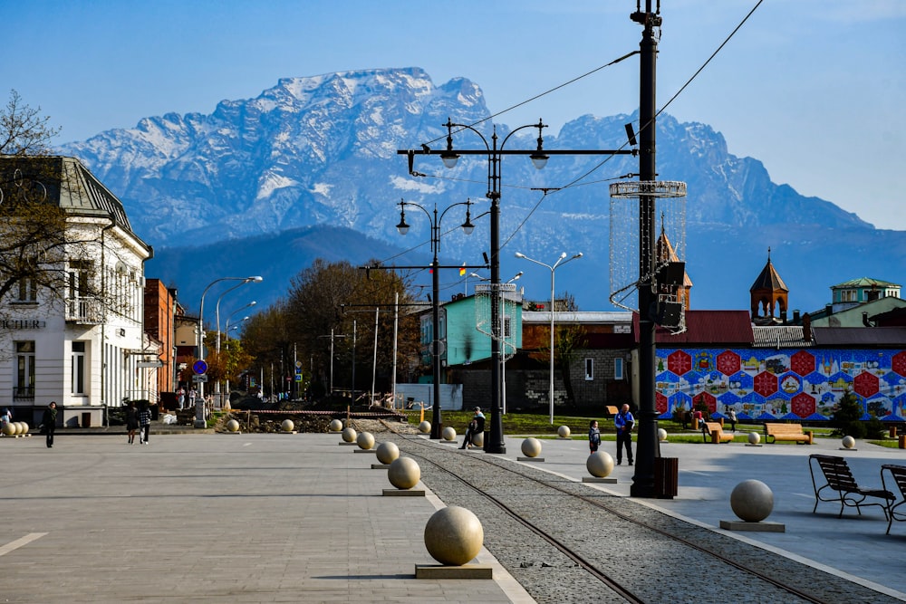 a train track with buildings and mountains in the background