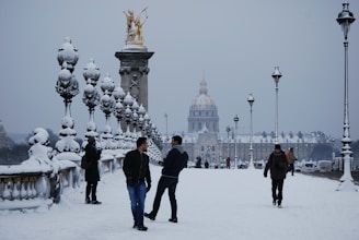 a group of people standing in the snow with a building in the background