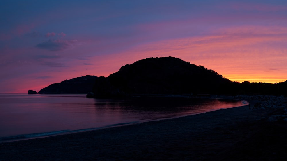 a beach with a hill in the background