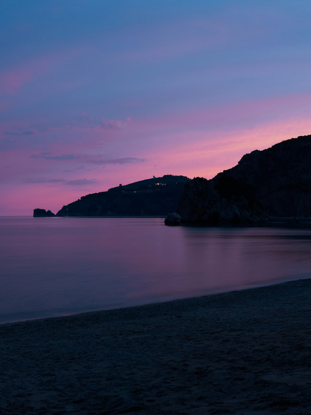 a body of water with hills in the background