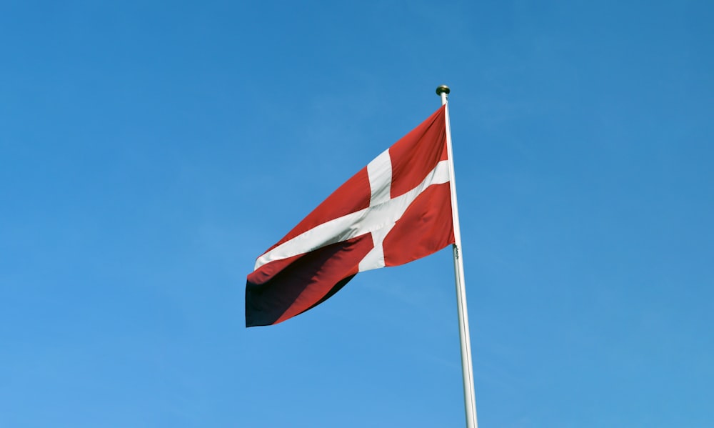 a red and white flag on a flagpole